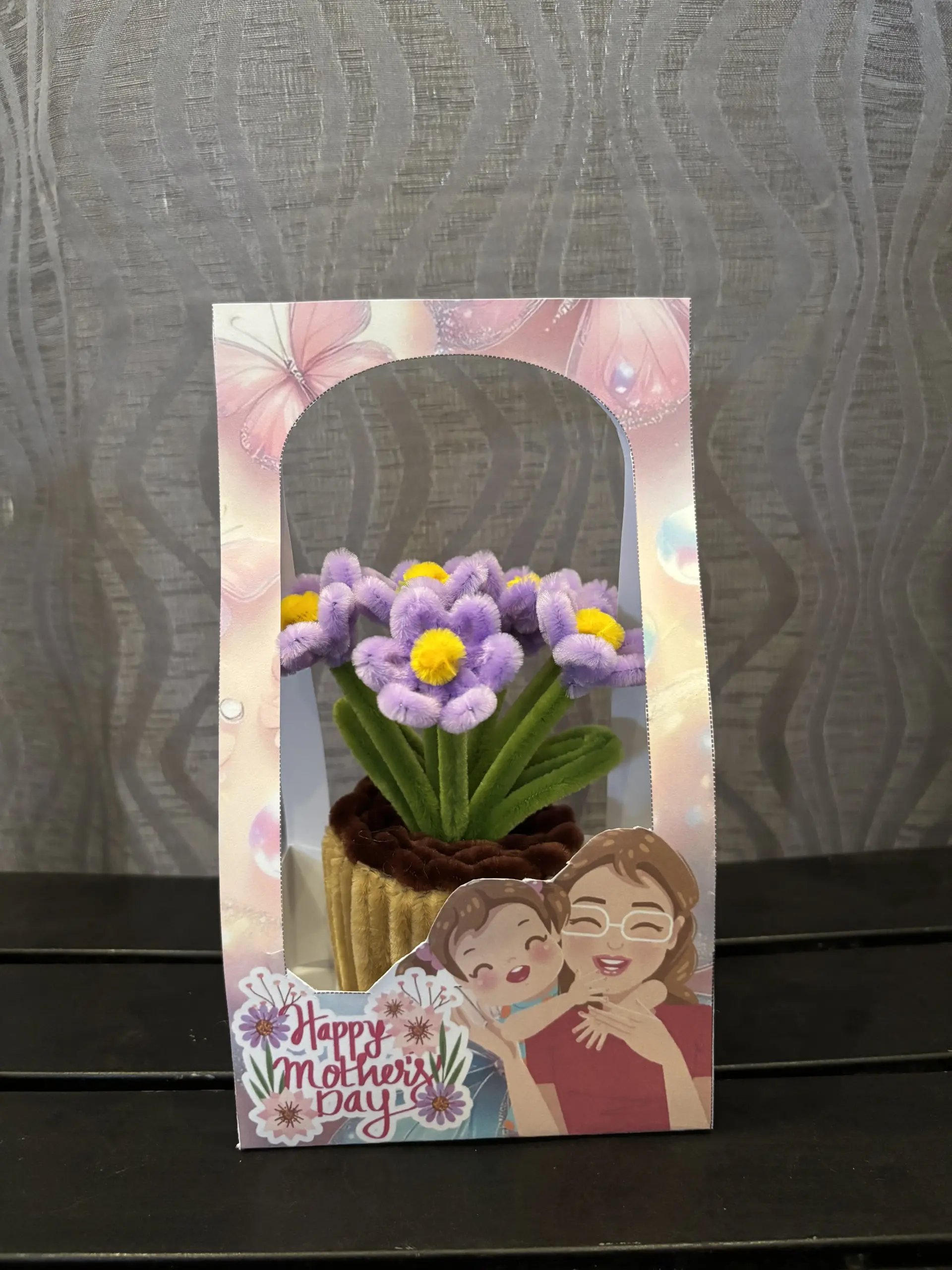 FleurKraft mini pot flower in mauve â€” handcrafted fuzzy wire flower in a woven basket pot, showing the finished product